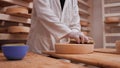 Worker cleaning and brushing the cheese wheels - traditional cheese maturation