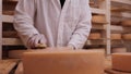 Worker cleaning and brushing the cheese wheels - traditional cheese maturation