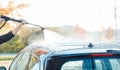 Worker cleaning car with high pressure water nozzle Royalty Free Stock Photo