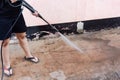 Worker cleaning dirty floor with high pressure washer Royalty Free Stock Photo