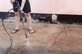 Worker cleaning dirty floor with high pressure washer Royalty Free Stock Photo