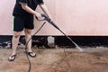 Worker cleaning dirty floor with high pressure washer Royalty Free Stock Photo