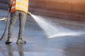 Worker cleaning driveway with gasoline high pressure washer splashing the dirt, asphalt road. High pressure cleaning Royalty Free Stock Photo