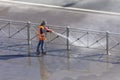 Worker cleaning driveway with gasoline high pressure washer splashing the dirt, asphalt road fence. High pressure cleaning Royalty Free Stock Photo