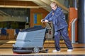Worker cleaning floor with machine Royalty Free Stock Photo