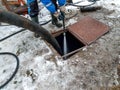 Worker cleaning the septic tank with water after emptying by sewage cleaner machinery