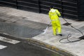 Worker cleaning the sidewalk with pressurized water