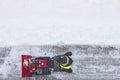 Worker cleaning snow on the sidewalk with a snowblower. Wintertime