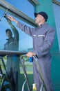 worker cleaning soap sud on window with squeegee Royalty Free Stock Photo