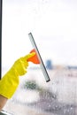 Worker cleaning soap suds on glass window with squeegee and rag Royalty Free Stock Photo