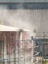 Worker cleaning storage tank by air pressure sand blasting. Royalty Free Stock Photo