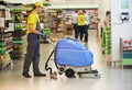 Worker cleaning store floor with machine Royalty Free Stock Photo