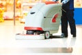 Worker cleaning store floor with machine Royalty Free Stock Photo