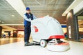 Worker cleaning store floor with machine Royalty Free Stock Photo