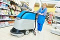 Worker cleaning store floor with machine Royalty Free Stock Photo