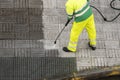 Worker cleaning the street sidewalk with high pressure water jet