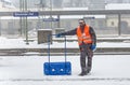 Worker is cleaning the train platform from snow in heavy snowstorm