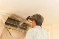 Worker cleaning wall air conditioner with high pressure water jet pump at home.