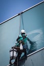 Worker cleaning windows service on high rise building Royalty Free Stock Photo