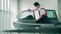 Worker is cleaning windshield of an autoboat