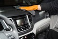Worker cleans cars using microfiber cloth to dry the dashboard during the process of hand-drying the interior of the car Royalty Free Stock Photo