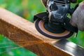 Worker cleans rust on steel closed profile using an electric wheel grinding machine