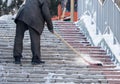 Worker cleans snow shovel in the nature