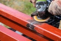 Worker cleans welding seam on steel closed profile using an electric wheel grinding machine