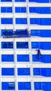A worker cleans windows on a tall skyscraper office building Royalty Free Stock Photo