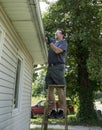 Worker Clearing Gutters Of Leaves & Sticks Royalty Free Stock Photo