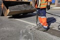 A worker clears a piece of asphalt with a pneumatic jackhammer in road construction Royalty Free Stock Photo