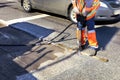 A worker clears a piece of asphalt with a pneumatic jackhammer in road construction Royalty Free Stock Photo