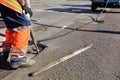 A worker clears a piece of asphalt with a pneumatic jackhammer in road construction Royalty Free Stock Photo