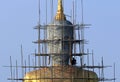 Worker renovates on buddha statue