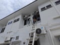 Worker climbed high up to the second storey building servicing the outlet air condition unit