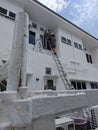 Worker climbed high up to the second storey building servicing the outlet air condition unit