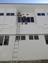 Worker climbed high up to the second storey building servicing the outlet air condition unit