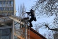 The worker climbs the side stairs to the roof of the building.