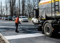 Worker, closing joints before laying asphalt