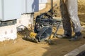 worker compresses sand in blind area around building with special working tool & x28;tamping machine or vibratory plate Royalty Free Stock Photo