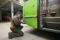 Worker conducting technical inspection for trolleybus parked at the trolley depot hangar