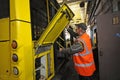 Worker conducting technical inspection for trolleybus parked at the trolley depot hangar