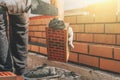 Worker at construction site applies cement mortar to brick for construction of brick house Royalty Free Stock Photo