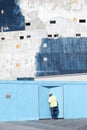 Worker on construction site with blue and turquoise concrete