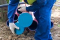 A worker at a construction site closes the ends of pipes with caps, close-up