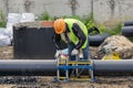 Worker at the construction site connects the pipes