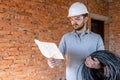 A worker at a construction site holds an electrical cable Royalty Free Stock Photo