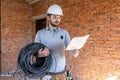 A worker at a construction site holds an electrical cable Royalty Free Stock Photo