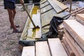 Worker at a construction site at home covers antiseptic boards. Impregnation of boards