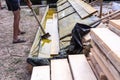 Worker at a construction site at home covers antiseptic boards. Impregnation of boards
